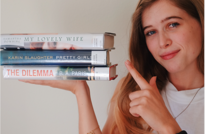 Blonde girl Yuki Reads holding three Palo Alto, California library books: The Lovely Wife by Samantha Downing, The Dilemma by B.A. Paris, Pretty Girls by Karin Slaughter